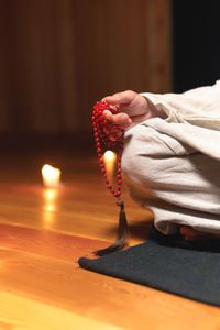 Low section of person with illuminated candles on background