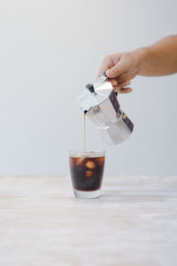 Moka pot coffee making iced mocha coffee in clean white room.