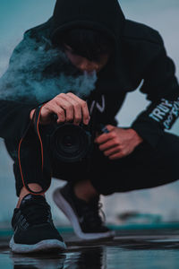 Midsection of man wearing hat while looking at camera