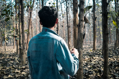 Man standing against trees in forest