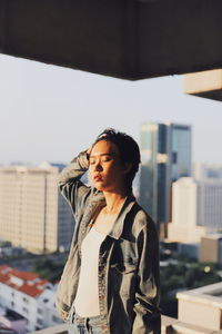 Young woman with eyes closed standing in city