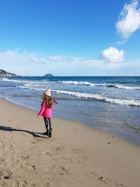 Full length of woman standing on beach against sky