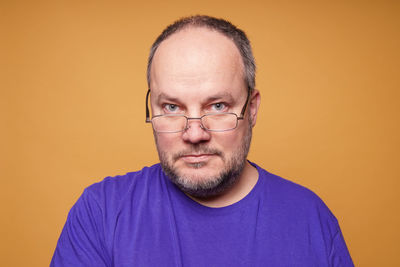 Portrait of young man against yellow background