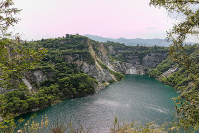 Scenic view of river amidst trees against sky