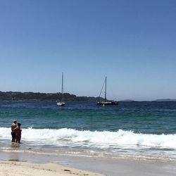 Man standing on beach against clear sky