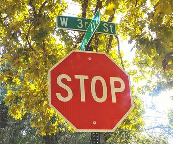 Low angle view of road sign against trees