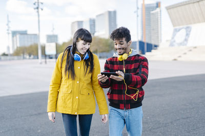 Young woman using mobile phone standing in city