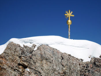 Low angle view of snow against clear blue sky