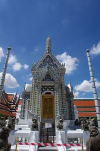 Low angle view of statue amidst buildings against sky