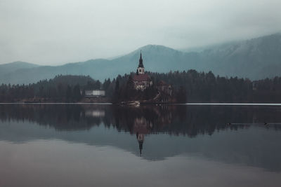 Scenic view of lake by buildings against sky lakebled