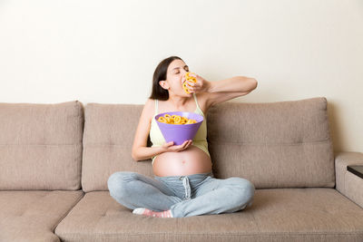 Midsection of woman sitting on sofa