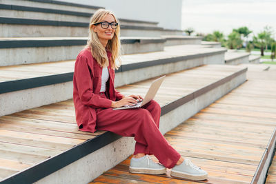 Business woman sitting on the stairs in the park working.