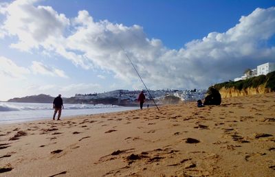 People on beach against sky