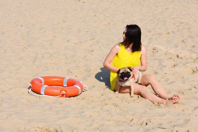 Full length of woman with dog on sand