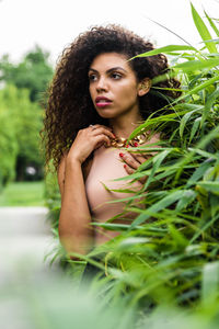 Portrait of beautiful woman against plants