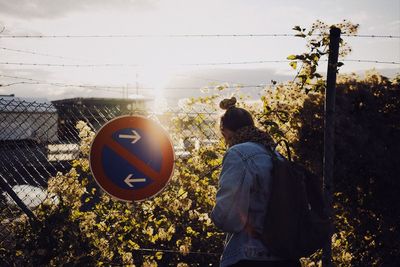 Rear view of man on tree against sky