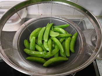 High angle view of green chili peppers in basket