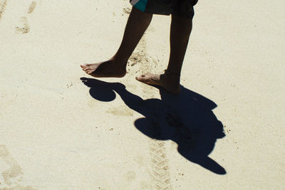 Low section of man shadow on sand