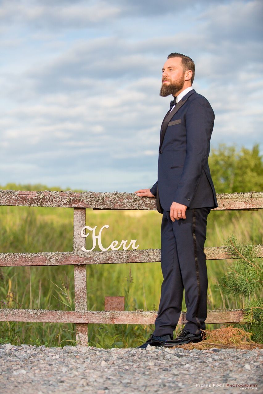 full length, standing, casual clothing, young men, leisure activity, young adult, sunglasses, cloud - sky, person, mountain, sky, in front of, water, day, handsome, looking, outdoors, tourism, tranquility, scenics