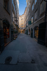 Empty road amidst buildings against sky
