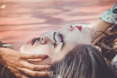 Close-up of friends lying outdoors