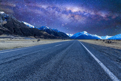 Road amidst snowcapped mountains against sky