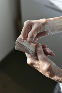 Close-up of person holding paper currency indoors