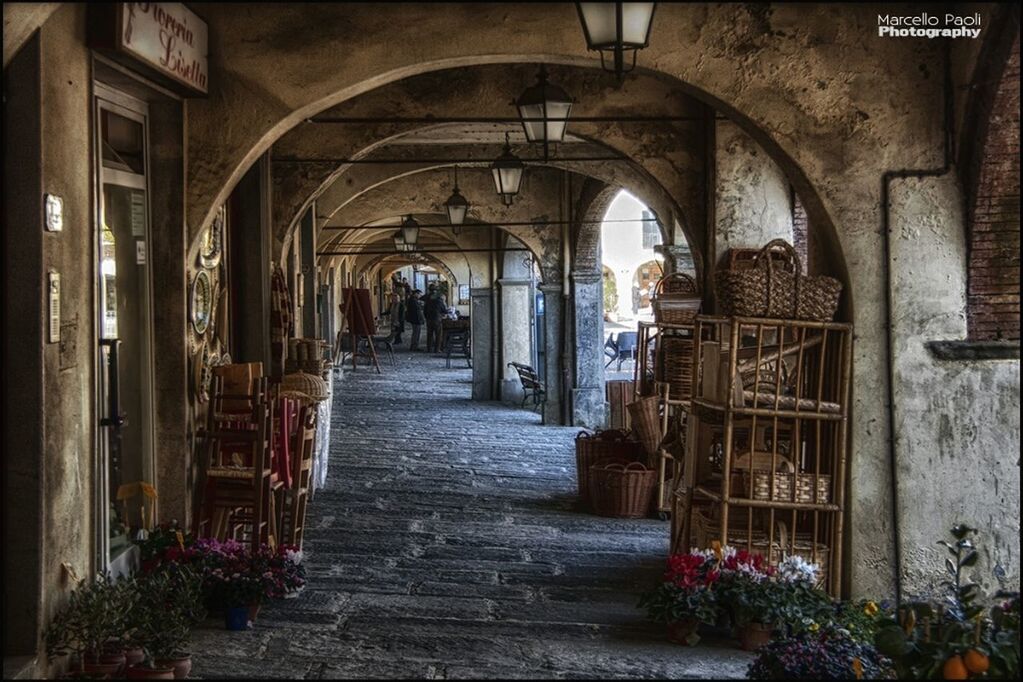 architecture, arch, built structure, building exterior, the way forward, entrance, architectural column, indoors, flower, place of worship, corridor, potted plant, incidental people, religion, day, archway, door, diminishing perspective, city, history