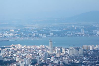 Aerial view of cityscape by sea against sky