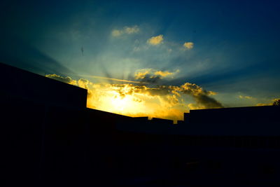 Silhouette built structures against scenic sky