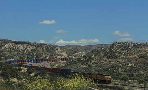 Train by mountain against sky