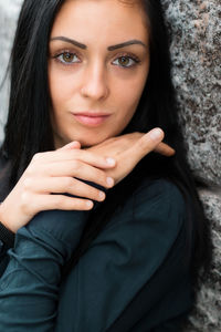 Portrait of beautiful young woman against wall