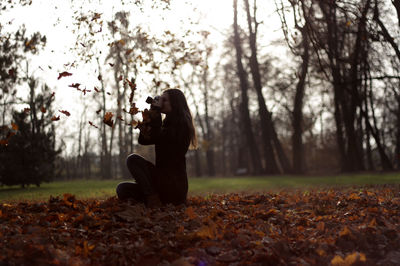 People sitting on grassy field in forest