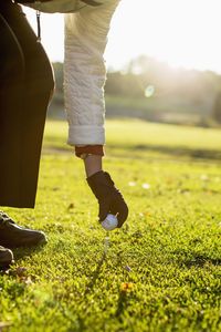 Low section of man standing on field