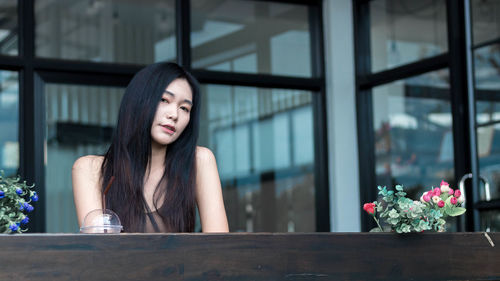 Portrait of beautiful woman sitting at table in cafe