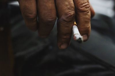 Cropped hand holding cigarette