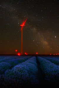 Scenic view of illuminated field against sky at night