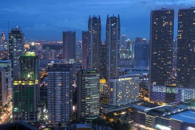 Aerial view of illuminated buildings in city against sky