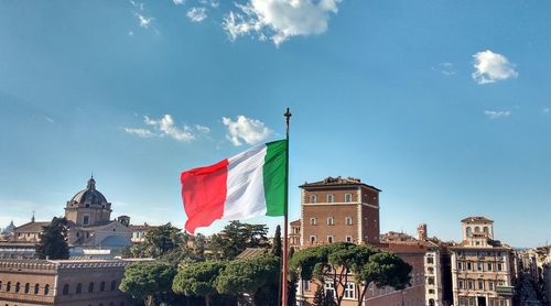 Low angle view of flags against cloudy sky