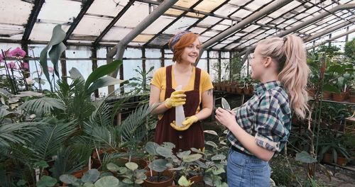 Women talking while planting in greenhouse