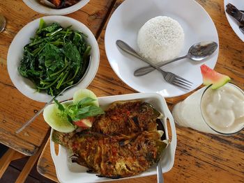 Dinner dishes such as fried carp, fresh vegetables, white rice and passion fruit juice for dinner
