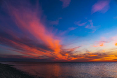 Scenic view of sea against romantic sky at sunset