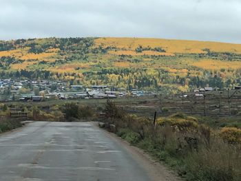 Scenic view of road amidst field against sky