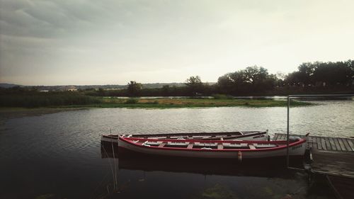 Boat moored on river against sky