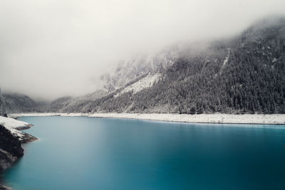 Scenic view of lake against sky during winter