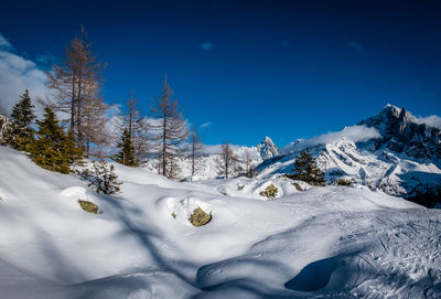 Snow covered mountains against blue sky