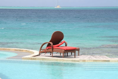 Deck chair at poolside by sea