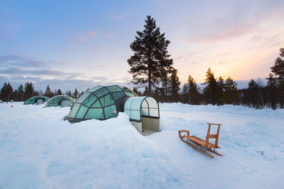 Scenic view of snow covered field against sky during sunset