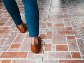 Low section of woman standing on tiled floor