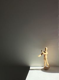 Figurine on table against wall